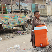A child carrying a water cooler