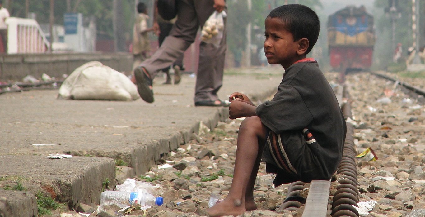 A child sitting beside railway tracks